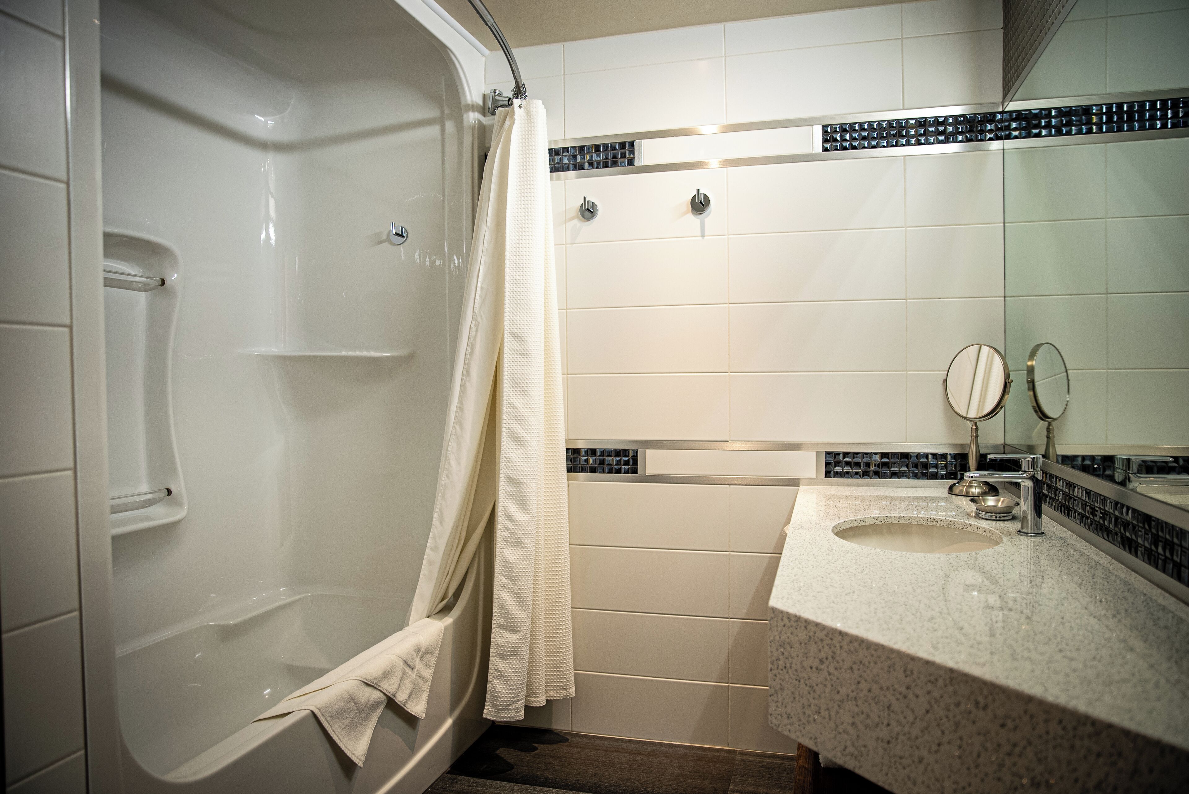 Ein Badezimmer mit einer Badewanne, einer Dusche, einem Waschbecken und einem Spiegel.