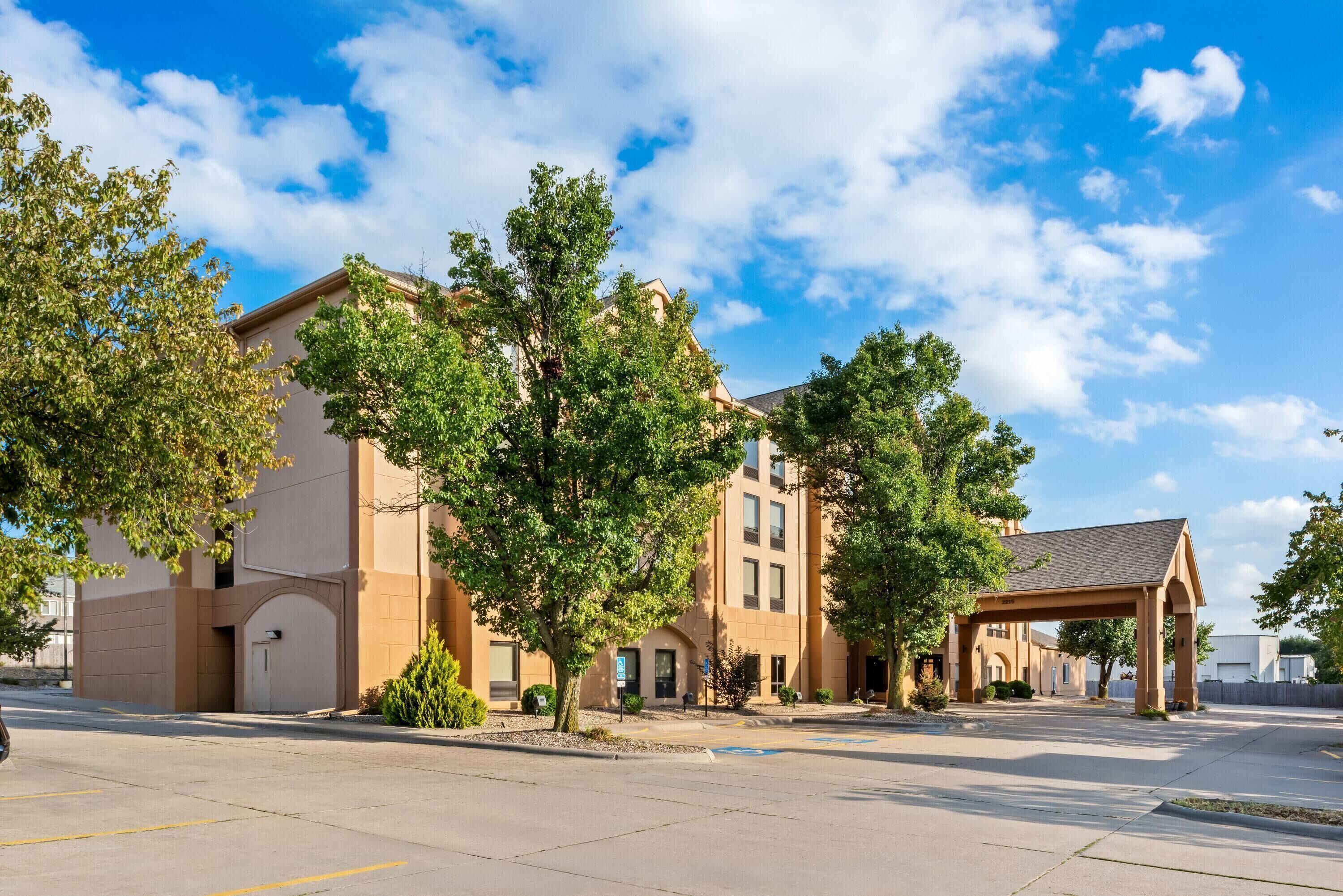 A multi-story building with a covered entrance and a parking lot.