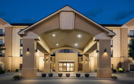 A hotel entrance with a covered walkway, large columns, and a symmetrical facade.