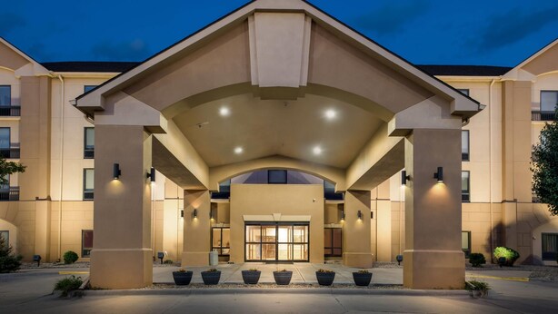 A hotel entrance with a covered walkway, large columns, and a symmetrical facade. - Days Inn & Suites by Wyndham Cedar Rapids (Cedar Rapids)