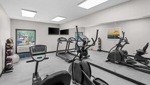 A gym with treadmills, elliptical machines, and a stationary bike. There are exercise balls and a rack of dumbbells. - Days Inn & Suites by Wyndham Cedar Rapids (Cedar Rapids)