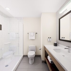A modern bathroom with a shower, toilet, and sink. - Garner Hotel Louisville East by IHG (Louisville)