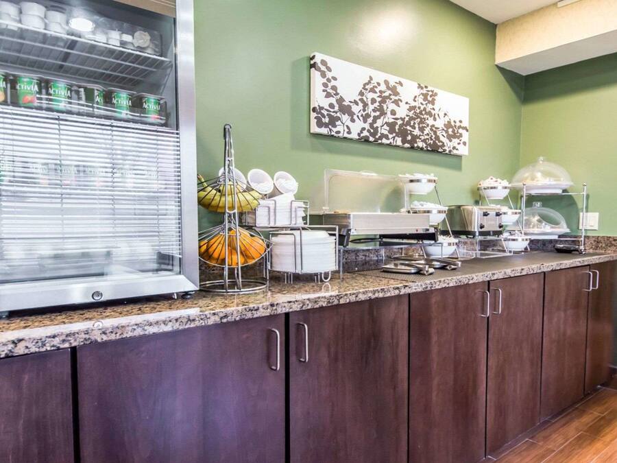 Disposição de buffet de café da manhã com diversos alimentos e utensílios.