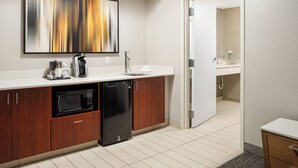 A modern kitchen with a microwave, coffee maker, and sink.
