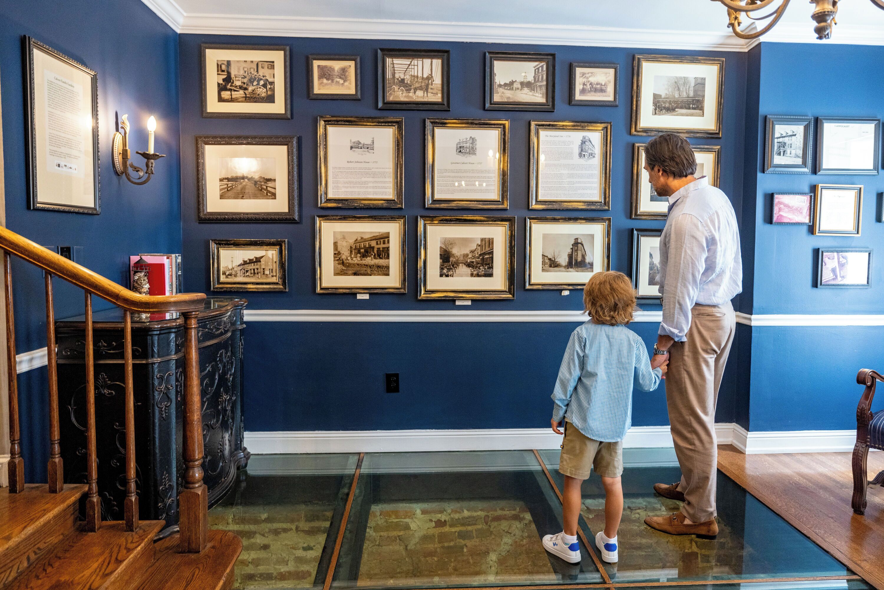 A room with a blue wall adorned with framed historical photographs.