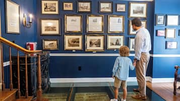 A room with a blue wall adorned with framed historical photographs.