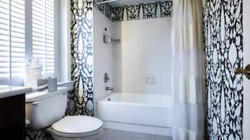 A bathroom with a toilet, bathtub, and shower curtain.