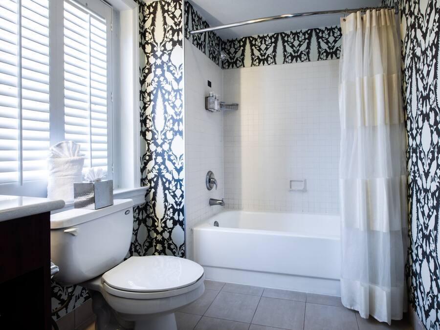 A bathroom with a toilet, bathtub, and shower curtain.