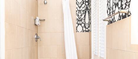 A bathroom with a bathtub, shower, and toilet.