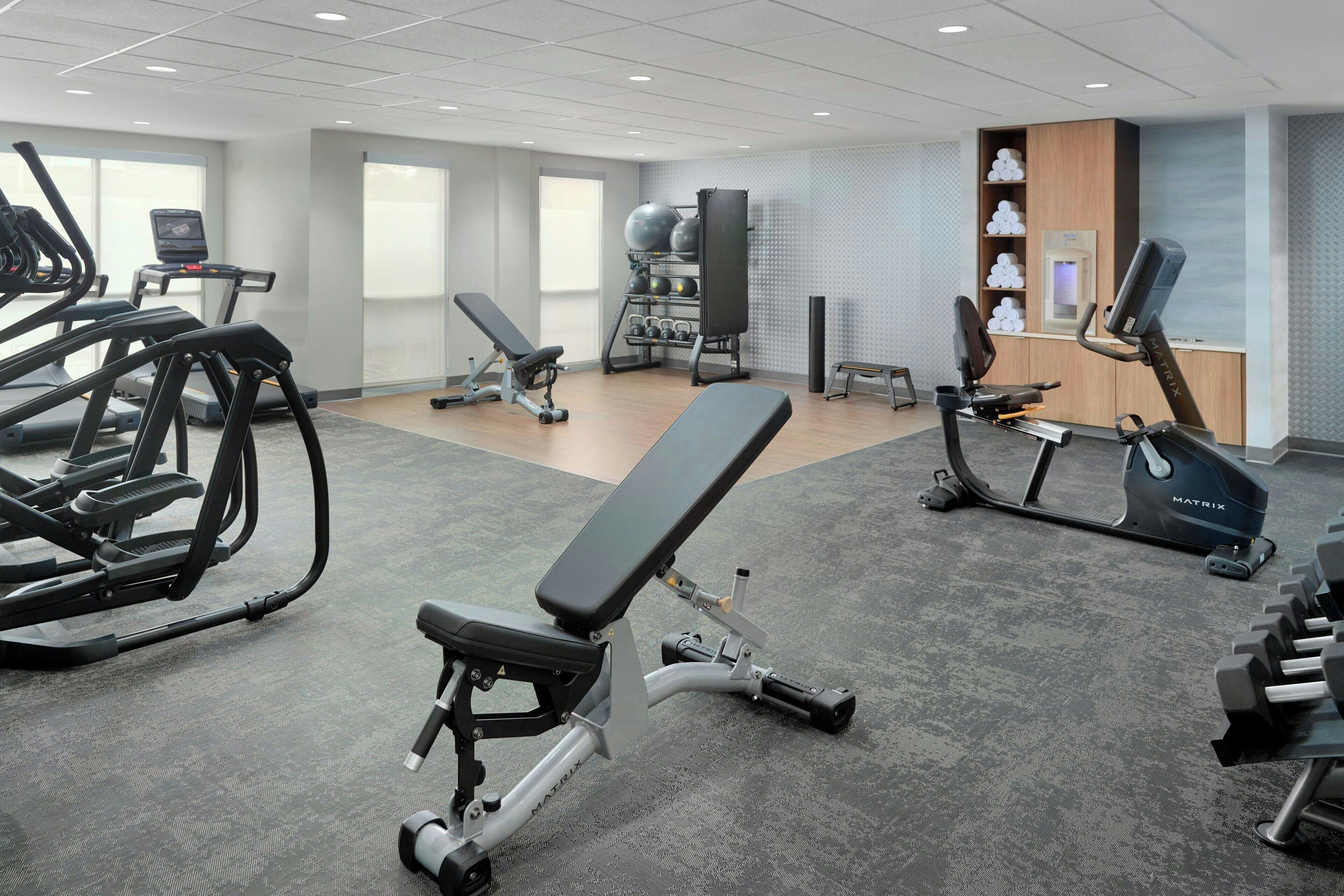 A gym with treadmills, elliptical machines, and free weights.