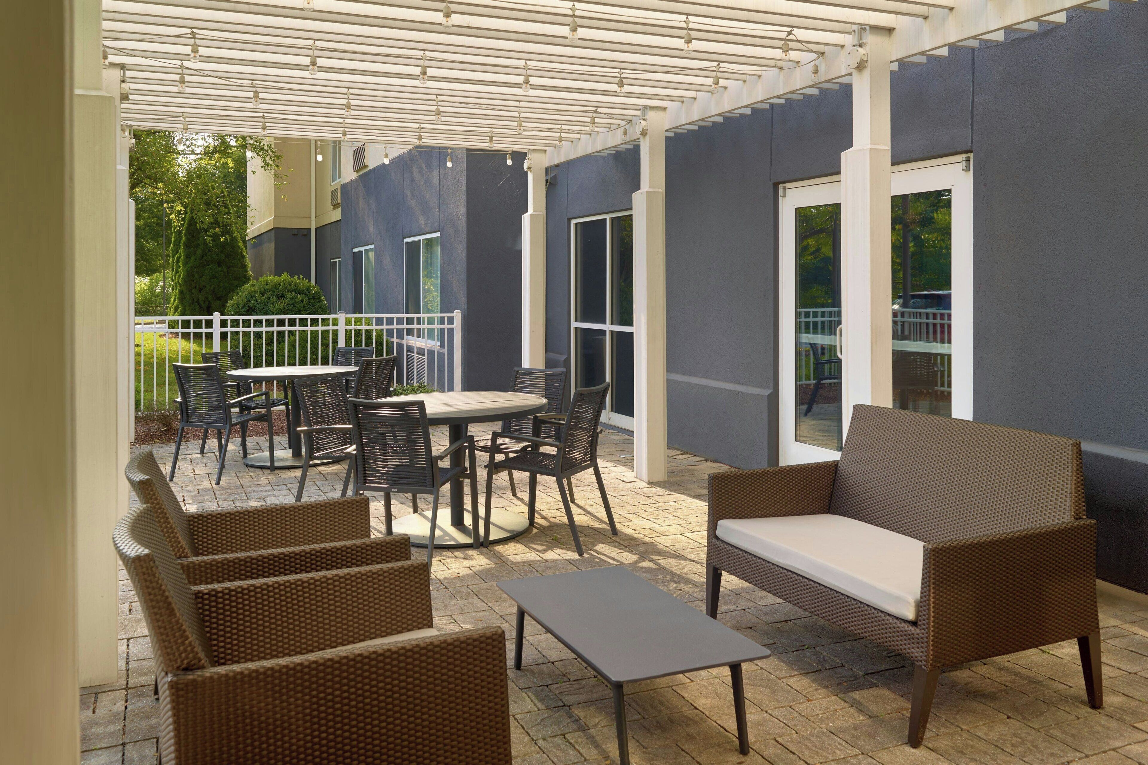 An outdoor patio with wicker furniture, a round table, and a sofa.