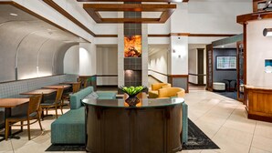 A lobby with a reception desk, seating area, and a large wall with a fire feature. - Hyatt Place Baltimore/BWI Airport (Linthicum Heights)
