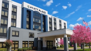 A modern Hyatt Place hotel with a prominent entrance, large windows, and a flag. - Hyatt Place Baltimore/BWI Airport (Linthicum Heights)