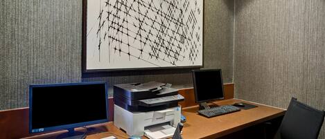 A workspace with two monitors, a printer, and a keyboard.