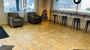 Un hall d’entrée avec deux fauteuils, un sapin de Noël et un coin bar avec des tabourets.