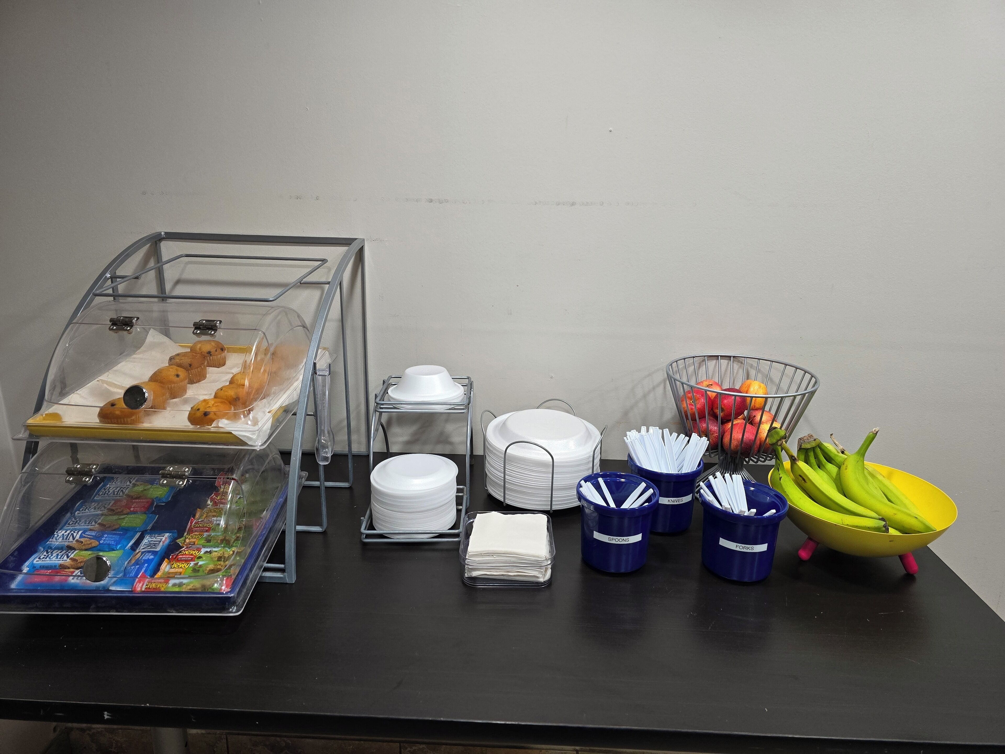 A buffet setup with various food items and utensils.