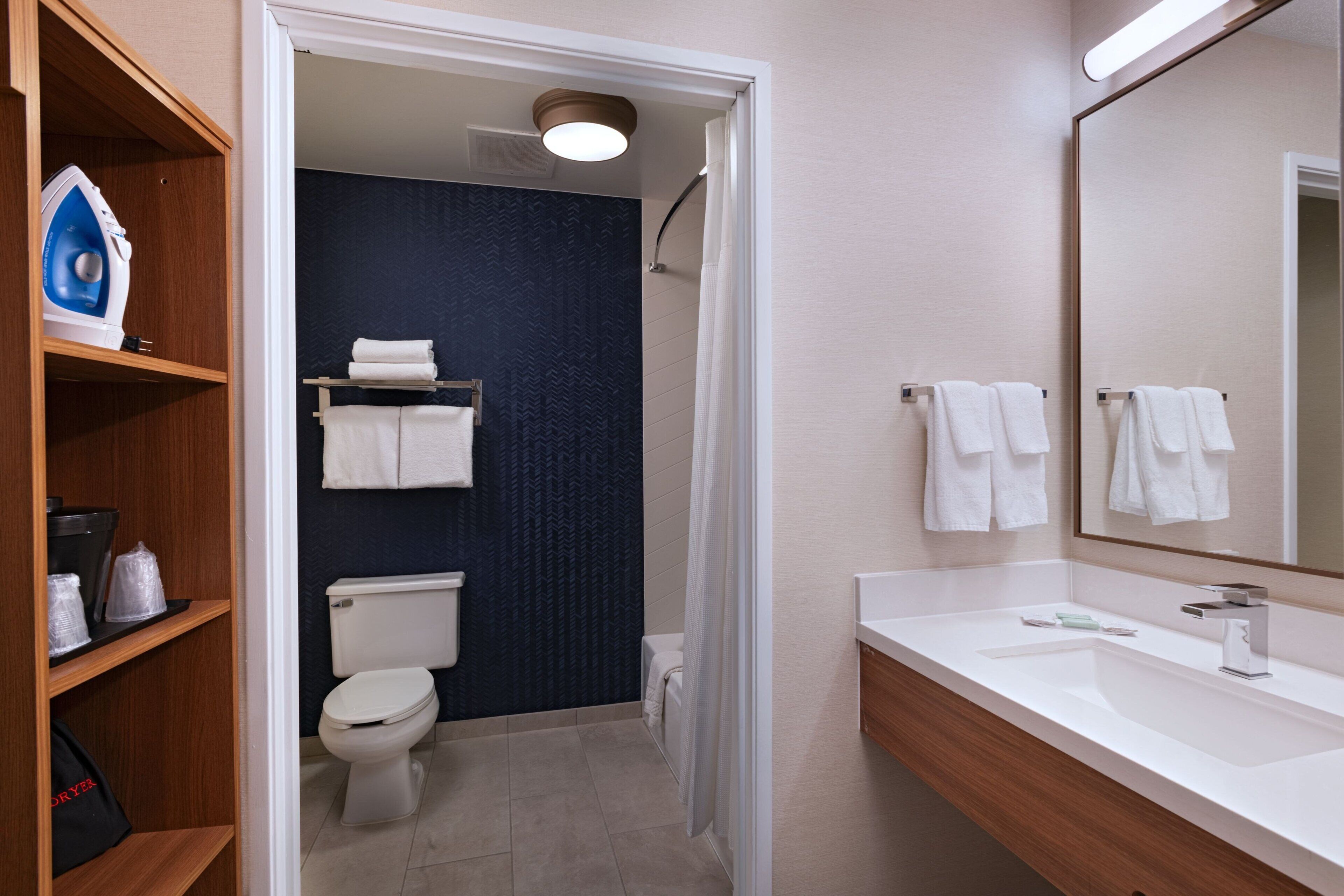 A bathroom with a white sink, a mirror, and a shower area.