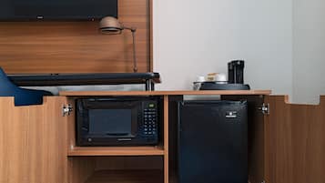 Eine kleine Küchenzeile mit Mikrowelle, Kühlschrank und Kaffeemaschine.