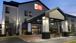A modern hotel with a prominent 'BW Best Western PLUS' sign, a covered entrance, and a well-maintained outdoor area with benches. - Best Western Plus Kansas City Airport-KCI East (Kansas City)