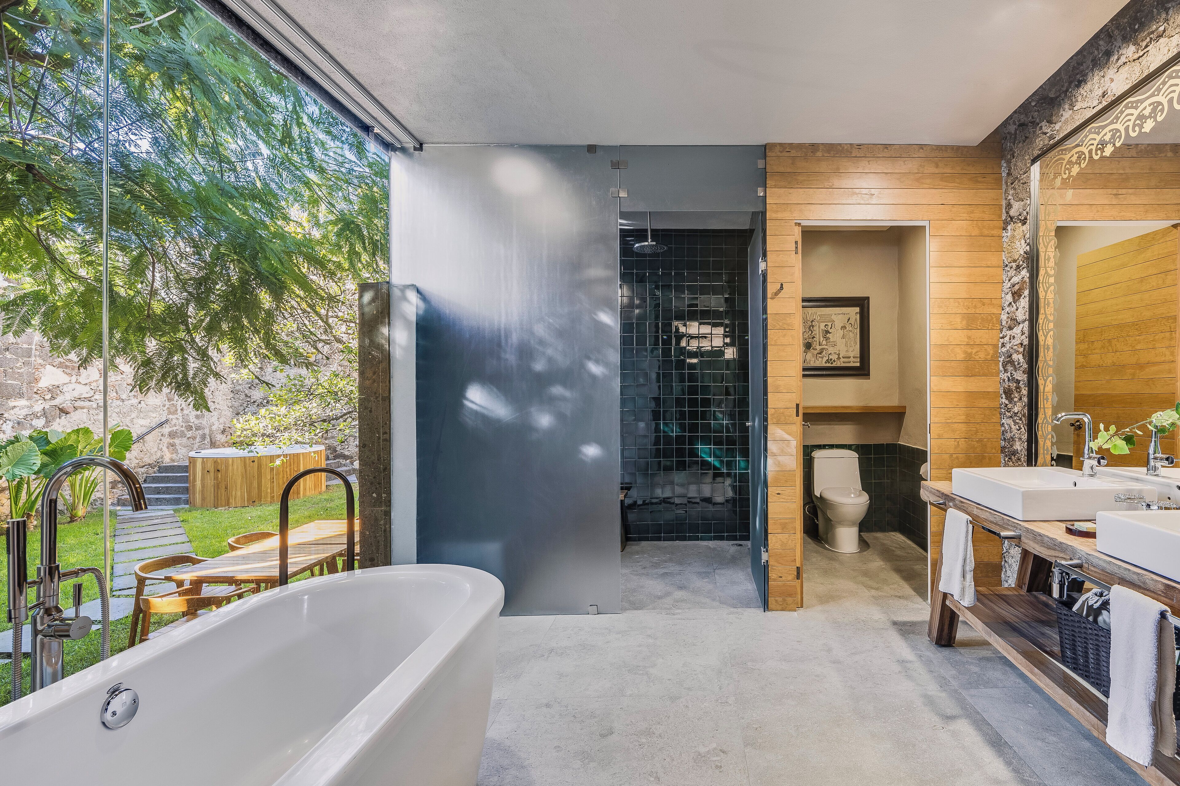 Un baño moderno con bañera, tocador de madera y un espejo grande.