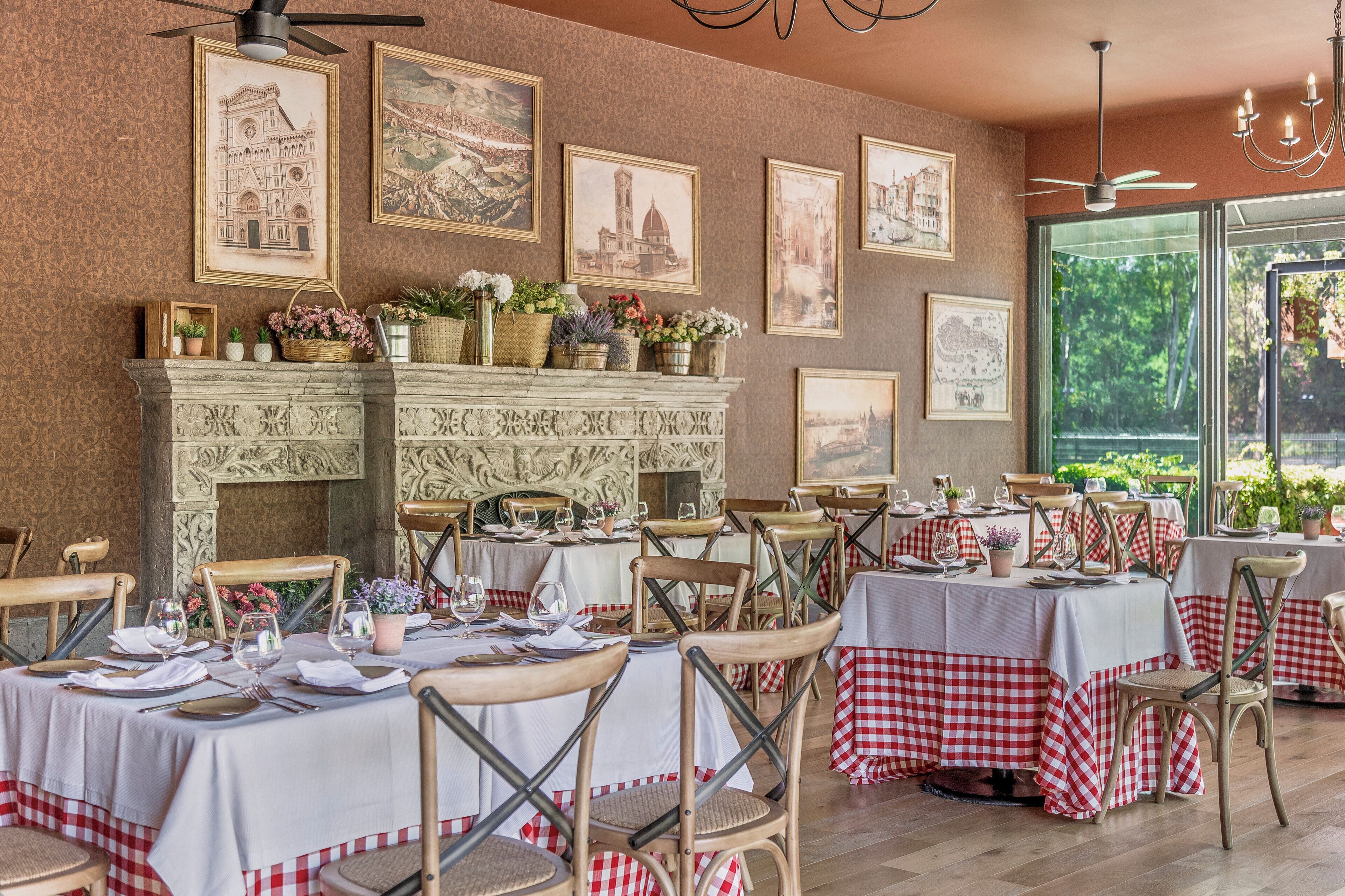Un restaurante con mesas dispuestas para comer, una chimenea decorada y cuadros en la pared.