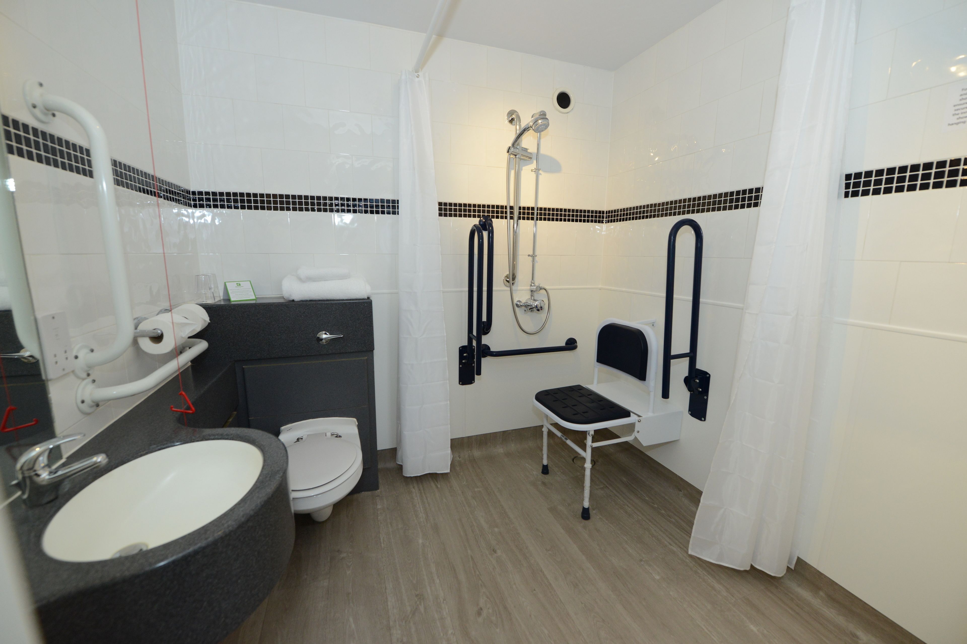 A compact bathroom with a sink, toilet, and shower.