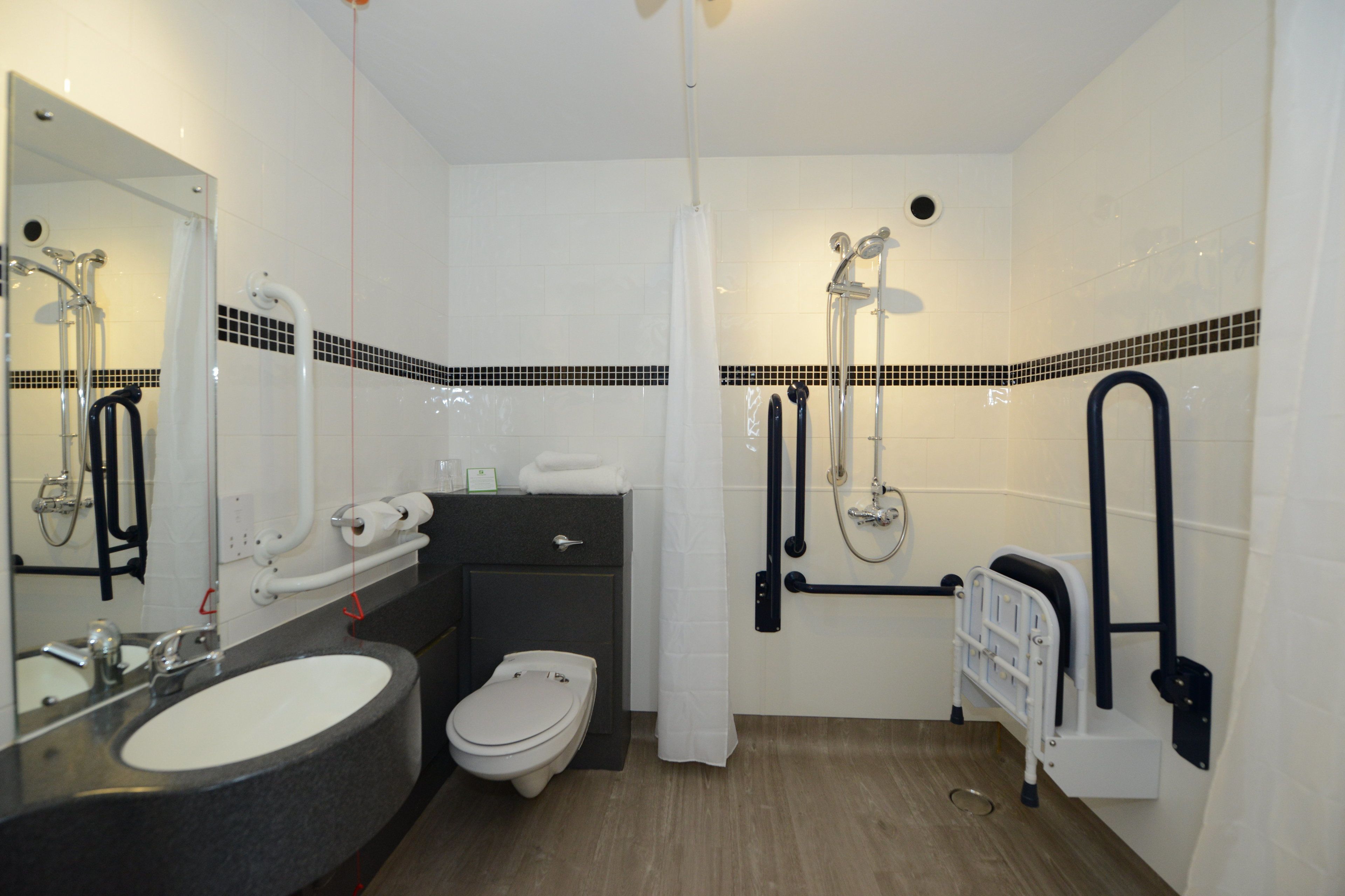 Une salle de bain moderne avec un lavabo, des toilettes et une douche.