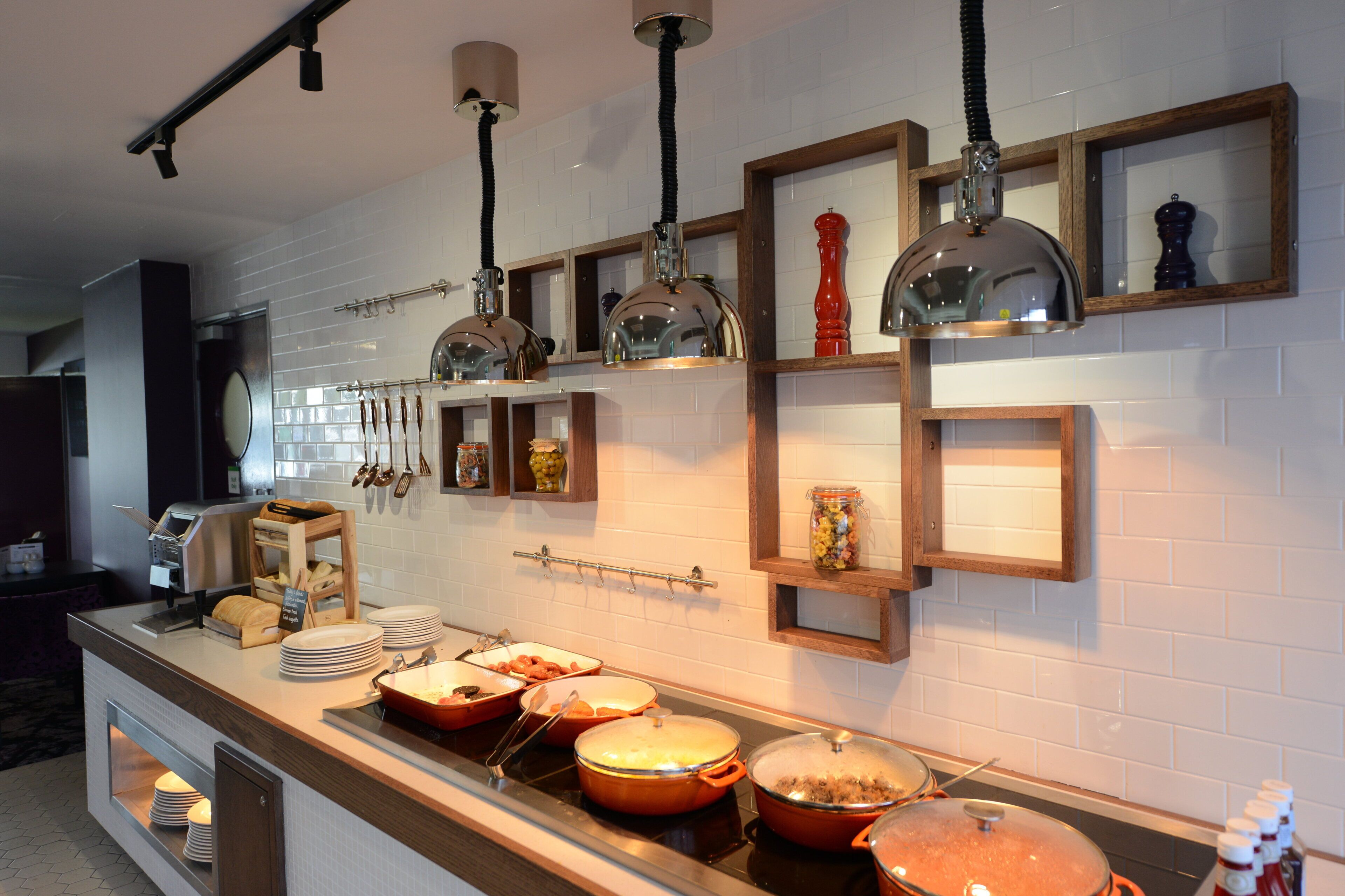 A buffet setup with various dishes and utensils.