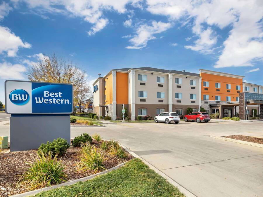 Un hotel Best Western con un letrero, un estacionamiento y un edificio moderno de varios pisos.