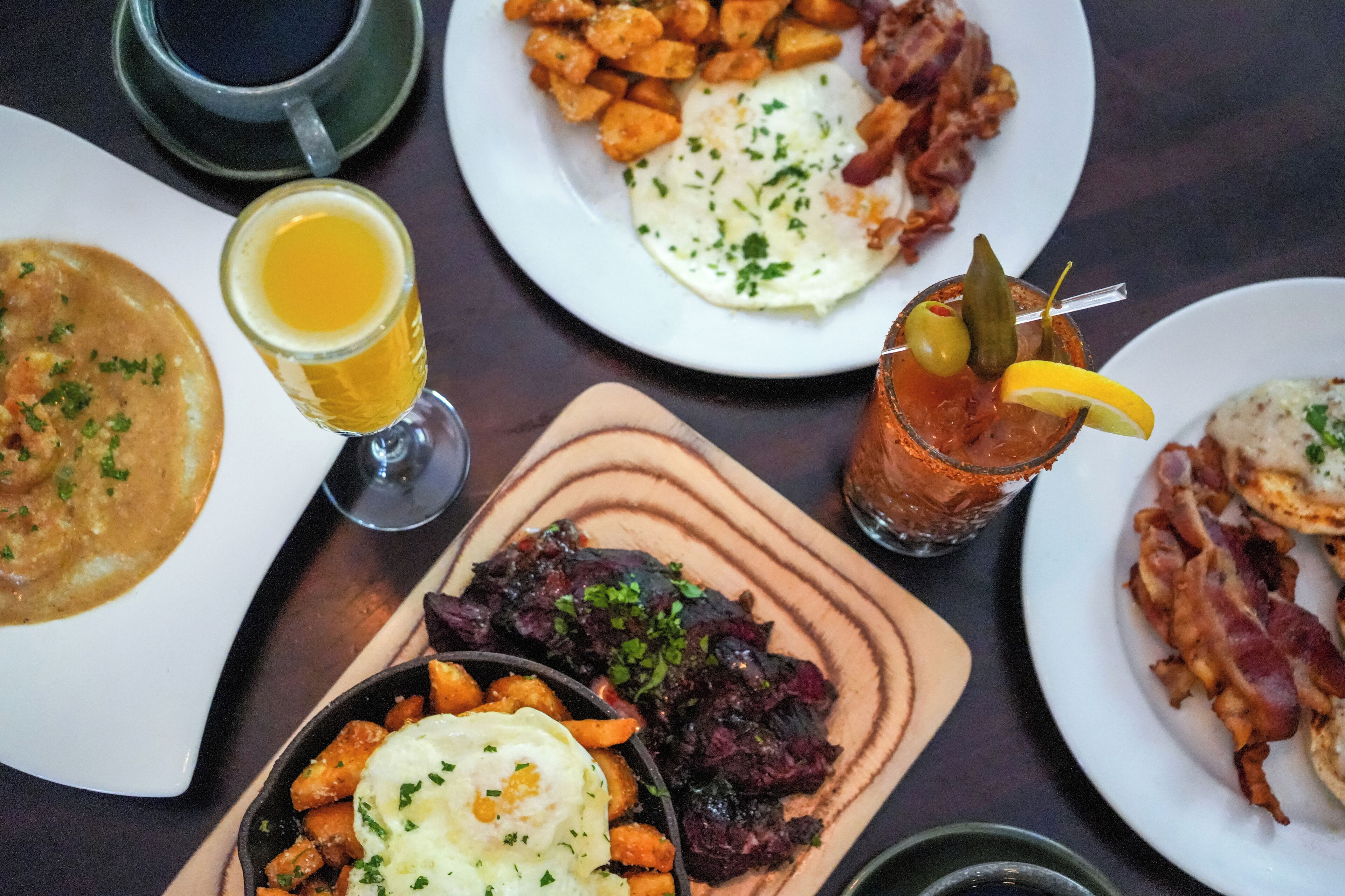 Diversos platos, incluyendo una fuente con huevos fritos, un tazón de sopa y un vaso de cerveza.