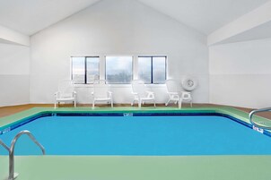 Una piscina techada, sillones reclinables de piscina