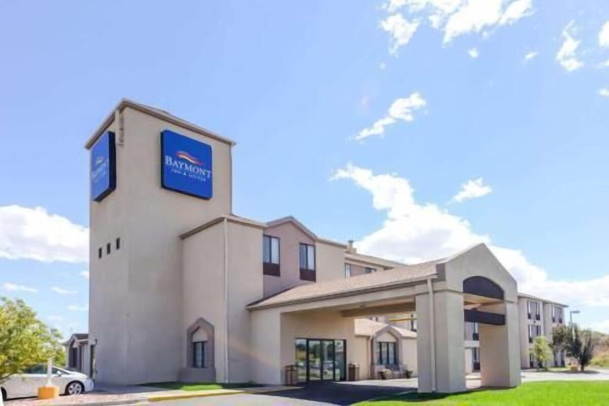 Un hôtel avec une enseigne bien visible, une entrée abritée et un espace de stationnement.