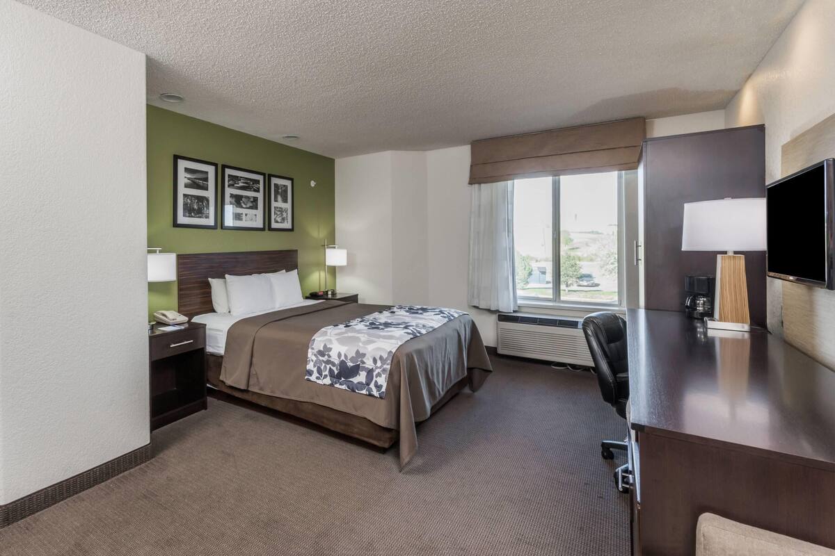 Ein Hotelzimmer mit Bett, Schreibtisch, Fernseher und einem Fenster mit Blick.