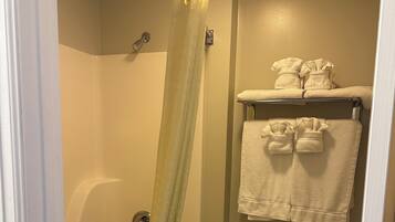 Un baño con bañera, inodoro y un perchero con toallas.