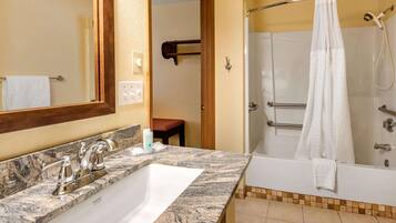 A bathroom with a marble sink, a bathtub, and a shower.
