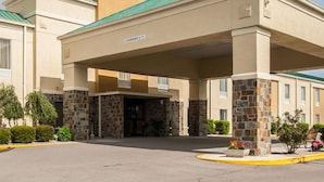 A hotel entrance with a covered driveway, stone pillars, and a sign indicating a clearance of 12 feet. - Quality Inn Hayti North (Hayti)