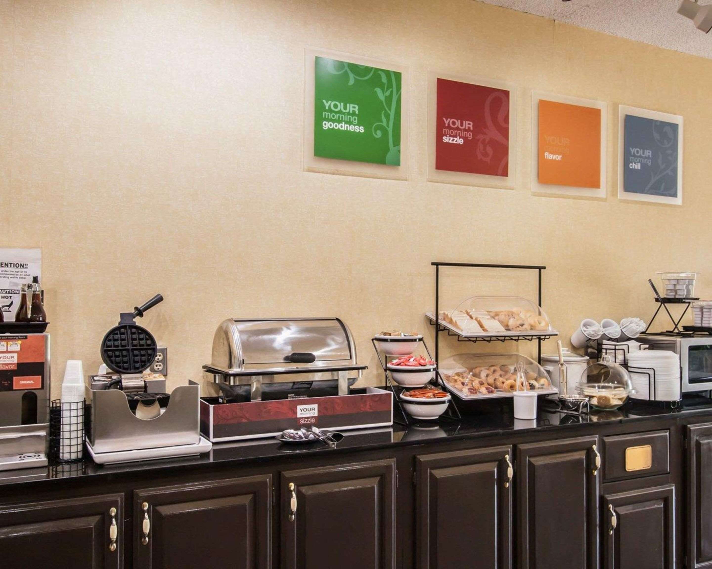 A breakfast buffet with various food items and a waffle maker.