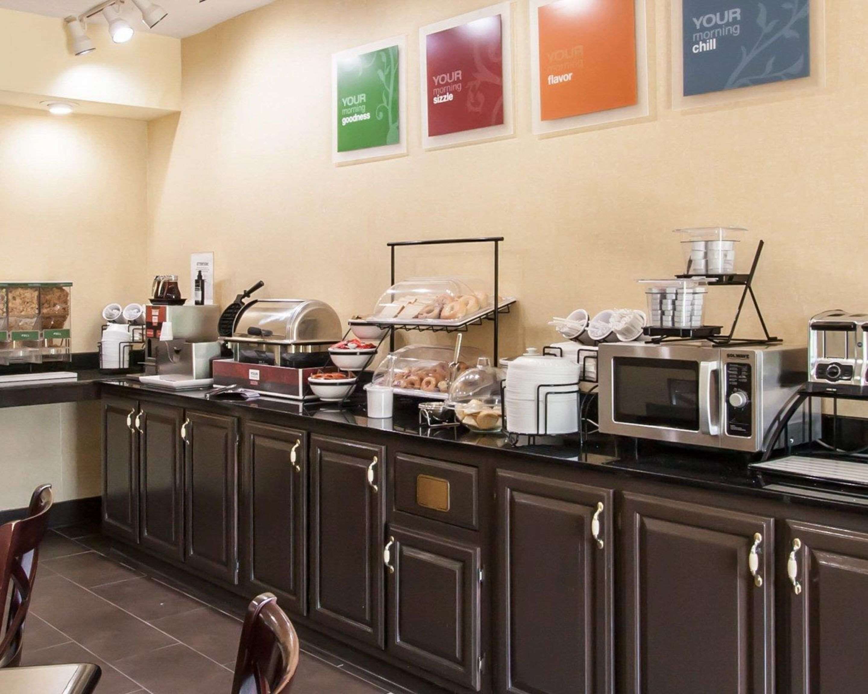 A breakfast buffet area with various food options, a coffee station, and a microwave.