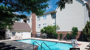 A swimming pool with lounge chairs and a lifeguard station.