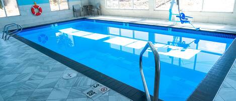 Une piscine avec une eau d’un bleu limpide, une bouée de sauvetage et un panneau indiquant une profondeur de 3 pieds.