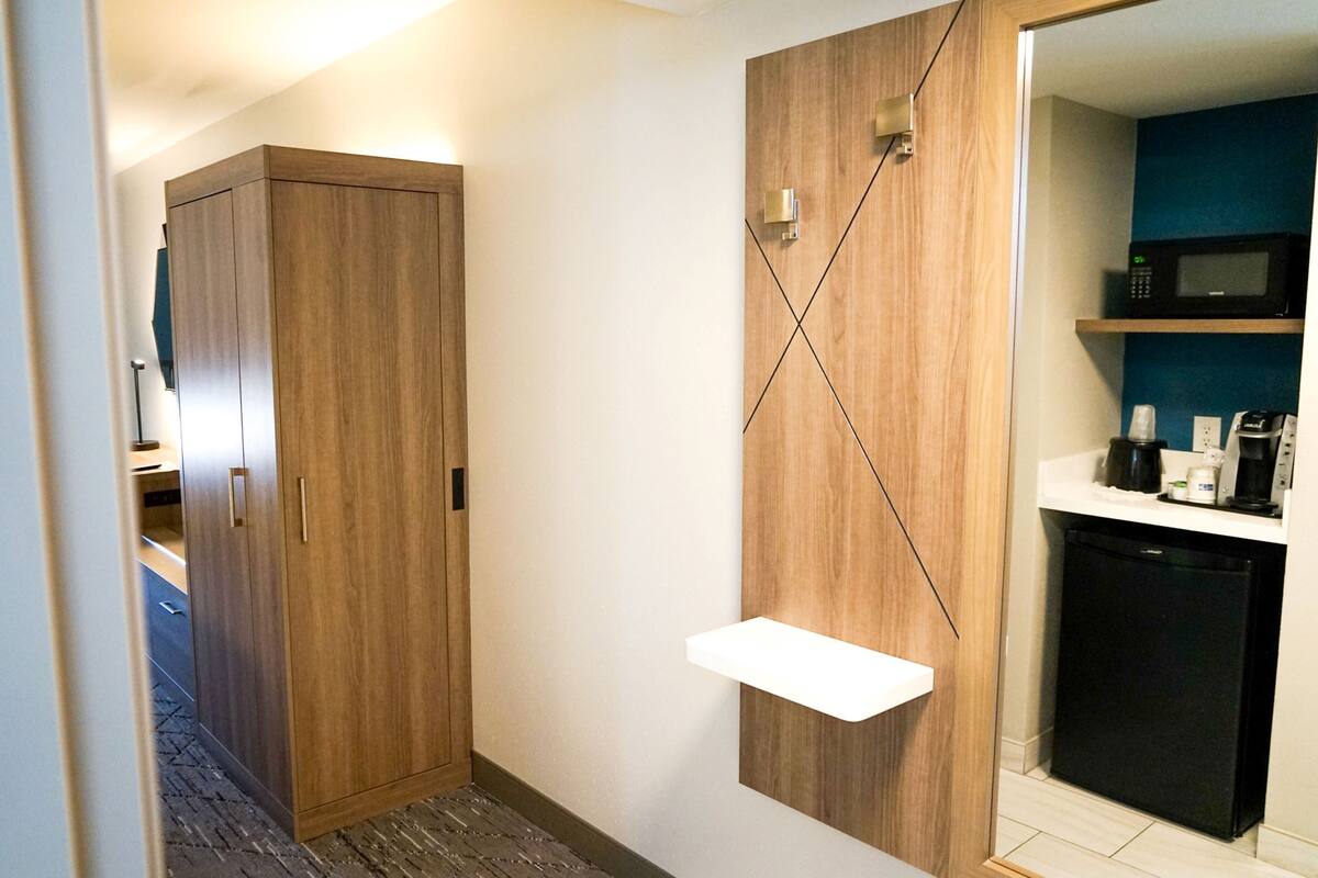 A compact kitchen with a microwave, coffee maker, and a small refrigerator.