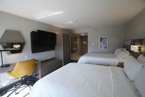 A hotel room with two beds, a desk, a chair, a TV, and a painting on the wall. - Holiday Inn Express La Junta by IHG (La Junta)