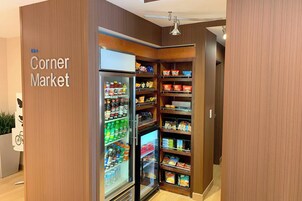 Un mercado de barrio con secciones refrigeradas y estantes llenos de bocadillos y bebidas.
