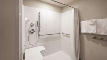 A shower area with a white toilet, grab bars, and a shower curtain.