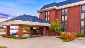 A modern hotel with a covered entrance, brick facade, and a parking area. - Heritage Inn & Suites St. Louis/Fenton, Trademark by Wyndham (Fenton)