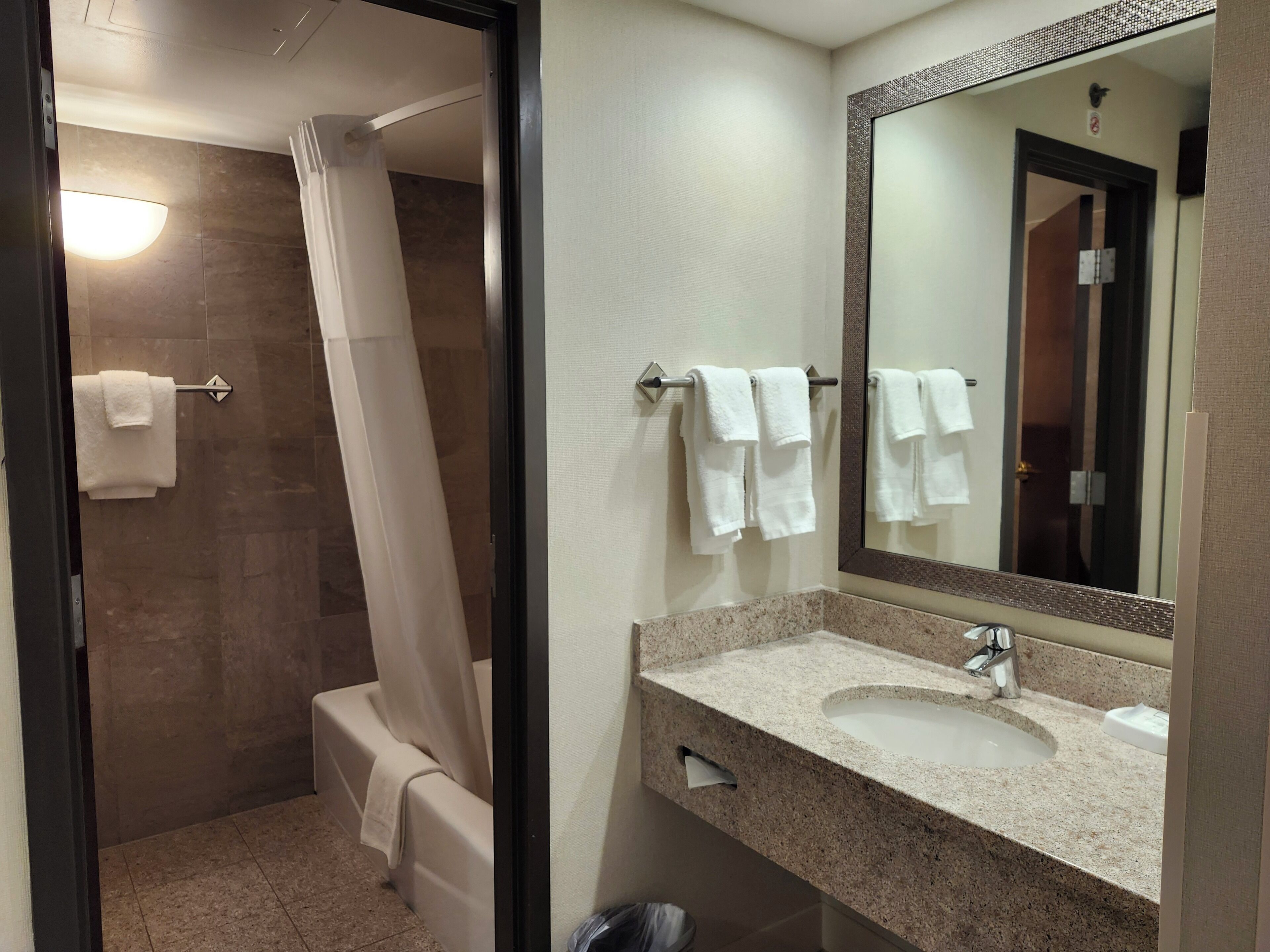 Une salle de bain moderne équipée d’une douche, d’un lavabo et d’un miroir.