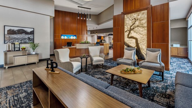 A modern hotel lobby with a seating area, a reception desk, and a large decorative wall. - Hyatt Place Phoenix/Chandler-Fashion Center (Chandler)