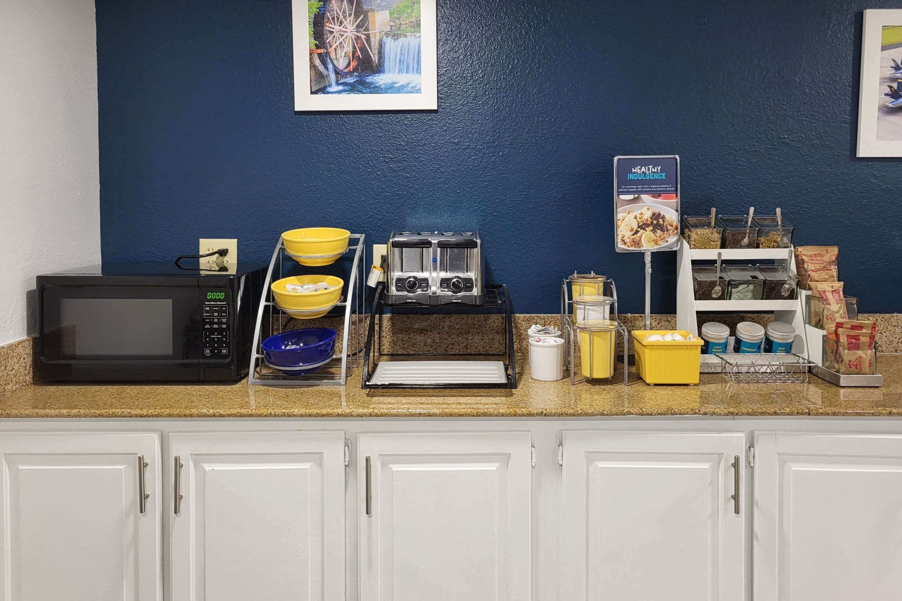 A kitchen area with a microwave, toaster, bowls, and a coffee station.