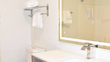 A bathroom with a toilet, sink, and mirror.