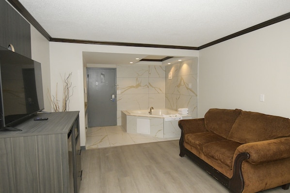 A modern living room with a brown sofa, a flat-screen TV, and a wooden cabinet.